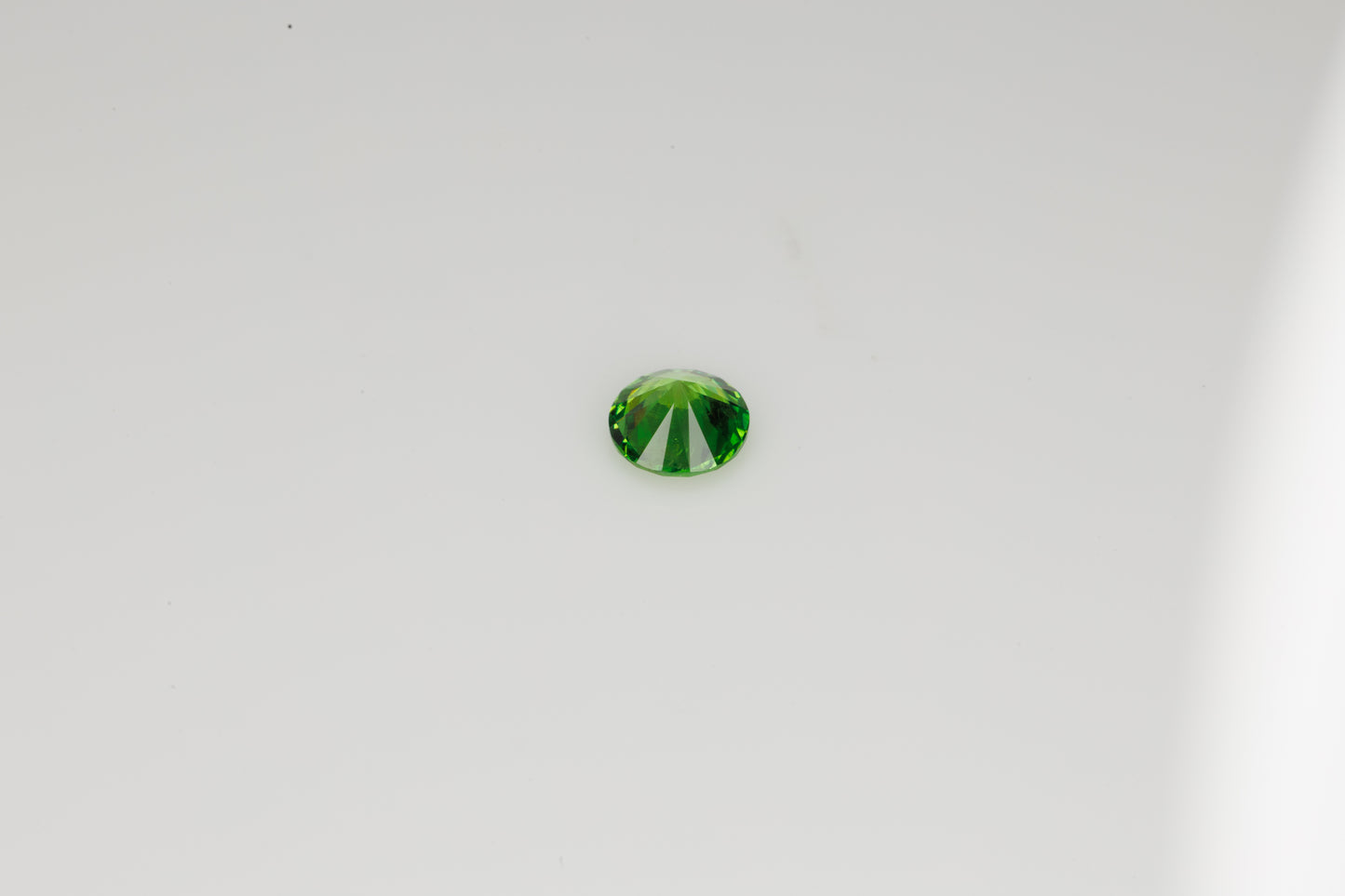 Vivid green faceted Russian demantoid garnet with byssolite inclusions, 0.32 ct