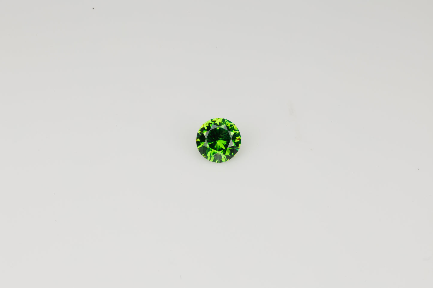 Vivid green faceted Russian demantoid garnet with byssolite inclusions, 0.27 ct