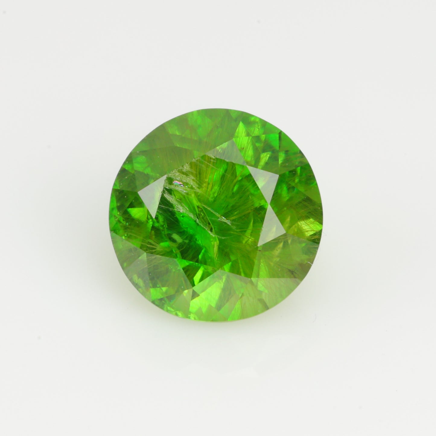 0.76 ct, Faceted Russian demantoid garnet with horsetail byssolite inclusions