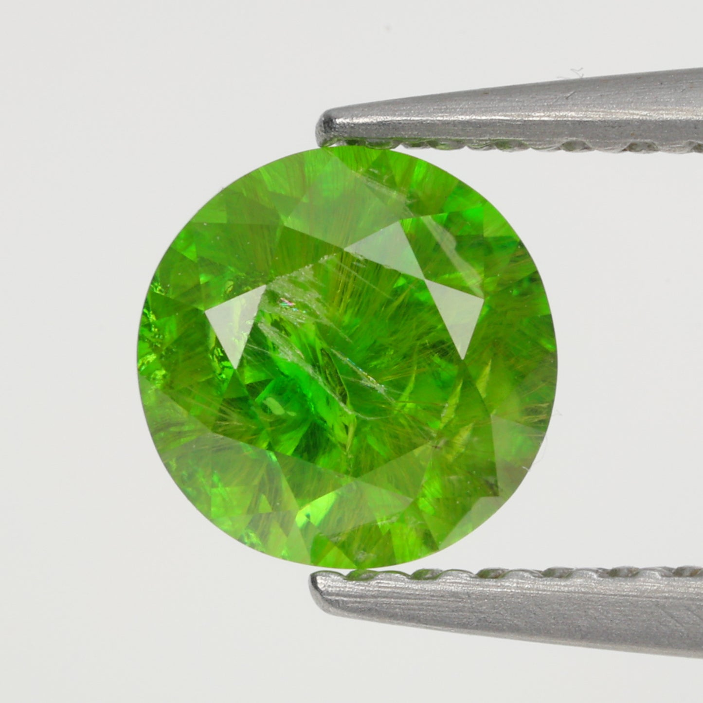 0.76 ct, Faceted Russian demantoid garnet with horsetail byssolite inclusions