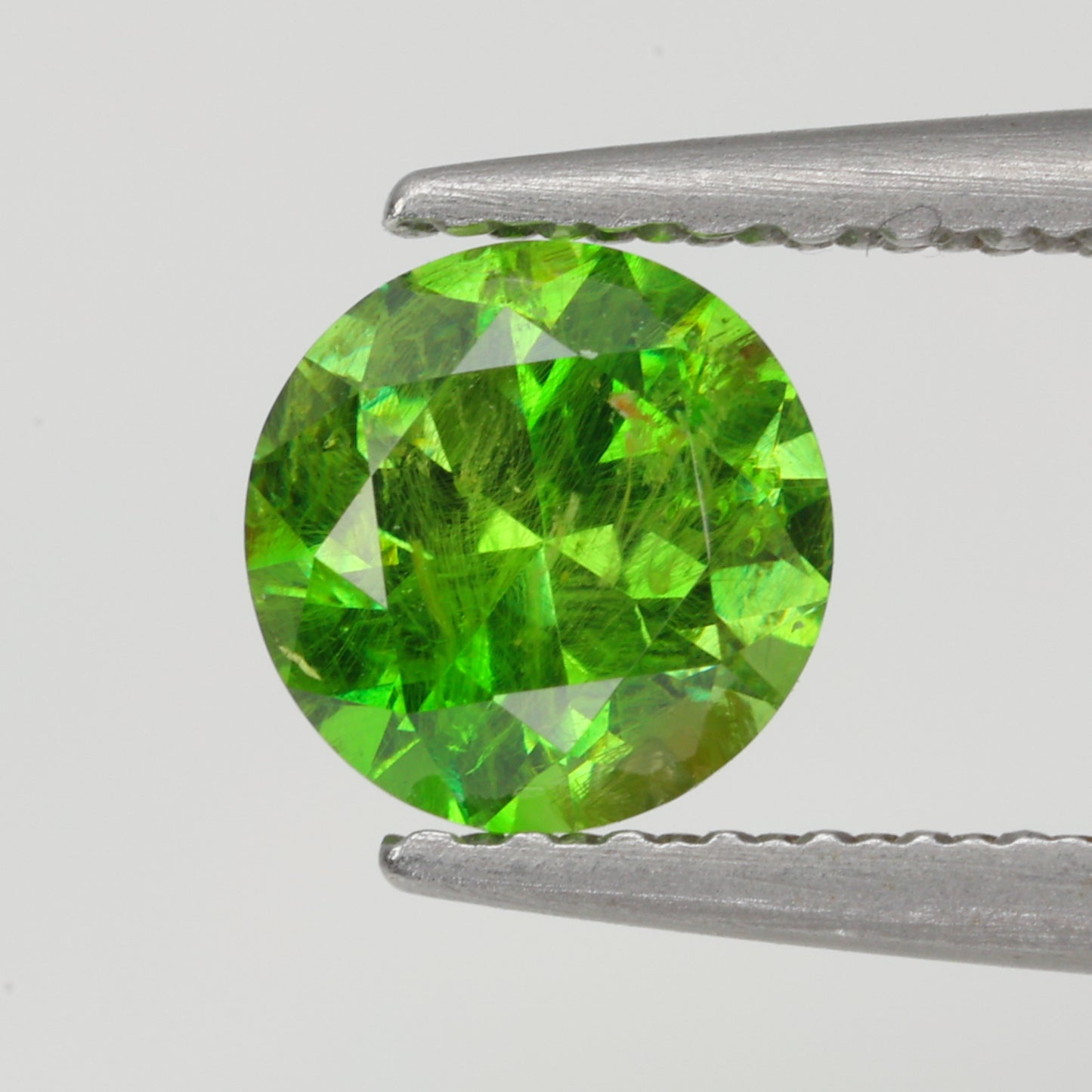 0.63 ct, Faceted Russian demantoid garnet with horsetail byssolite inclusions