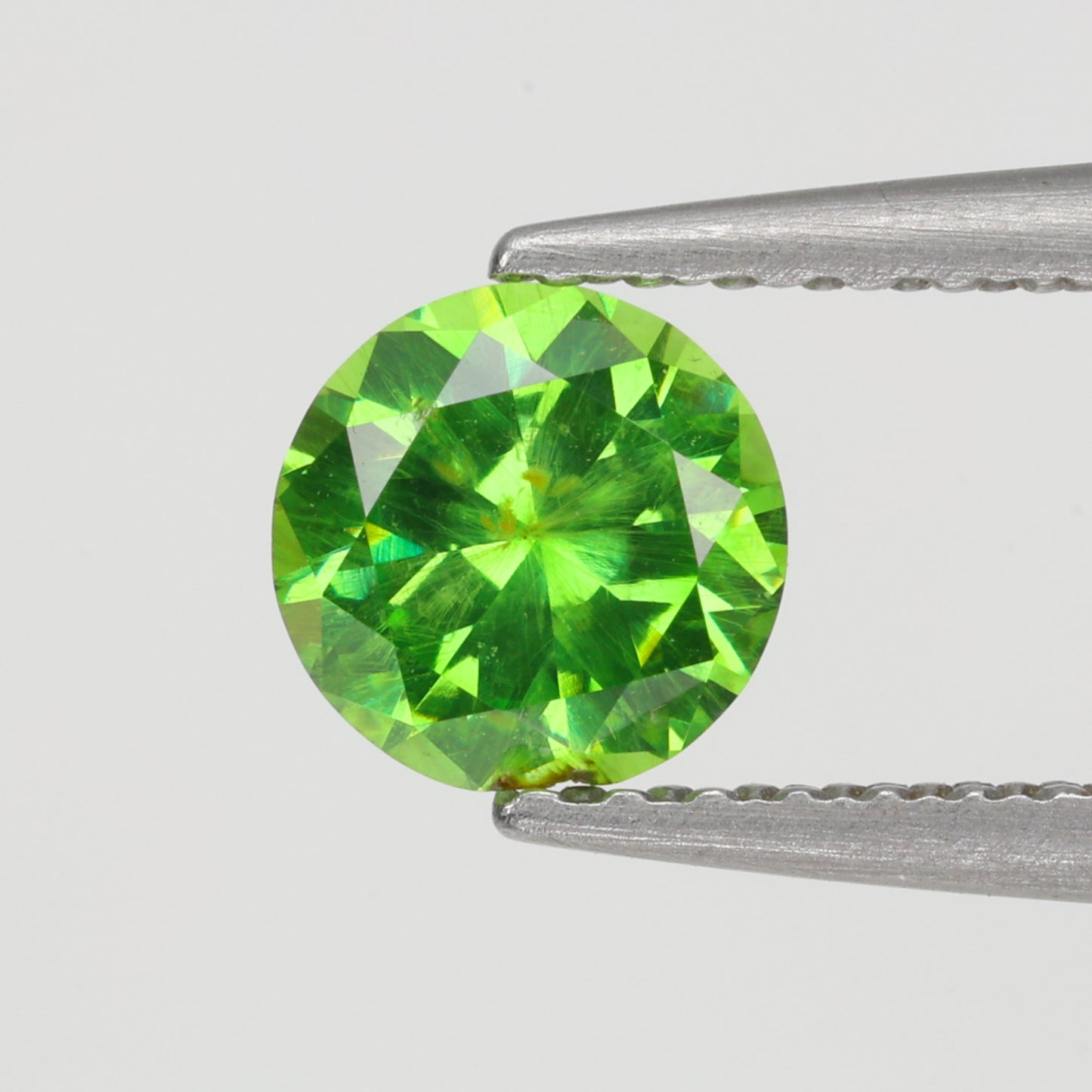 0.52 ct, Faceted Russian demantoid garnet with horsetail byssolite inclusions
