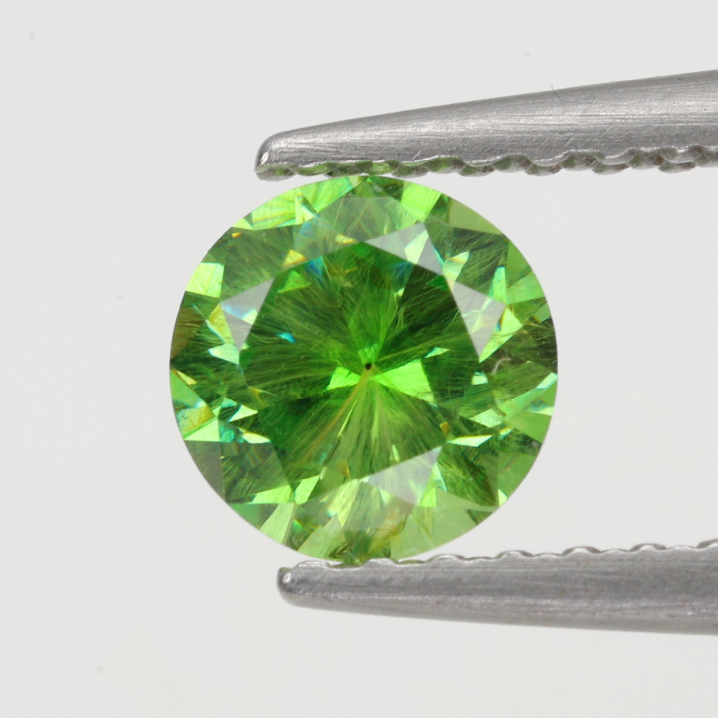0.52 ct, Faceted Russian demantoid garnet with firework horsetail inclusions