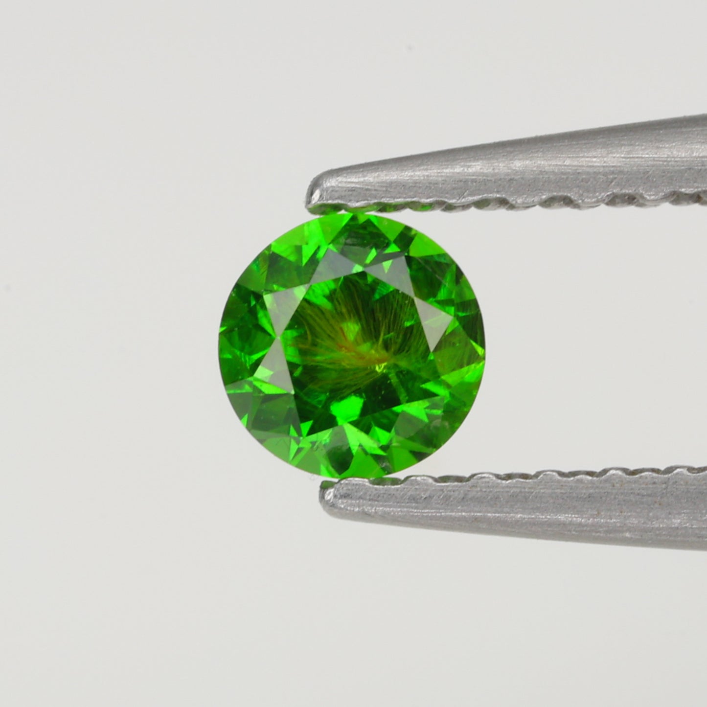 0.22 ct, Faceted Russian demantoid garnet high with horsetail inclusion