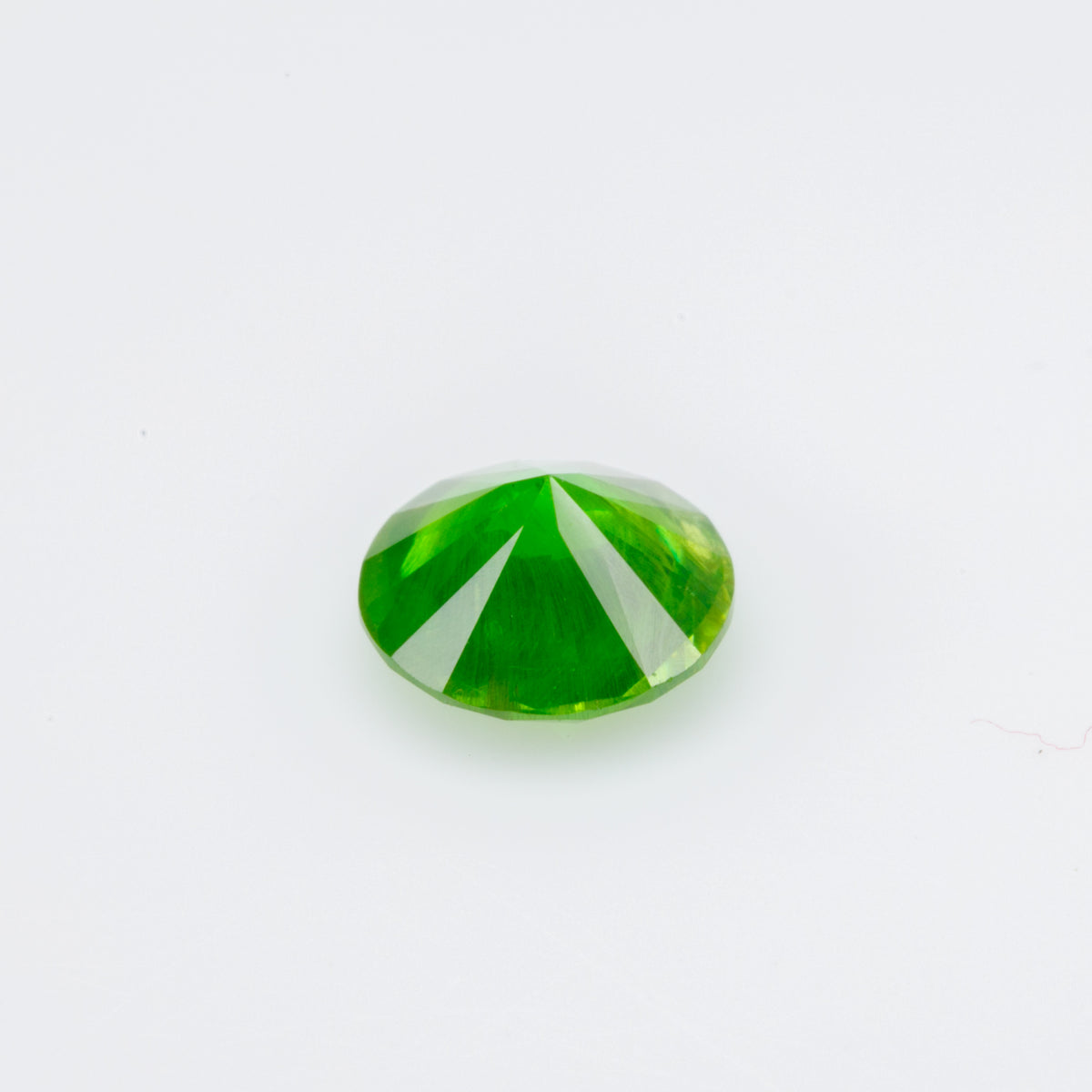 0.55 ct, Faceted Russian demantoid garnet with horsetail inclusion