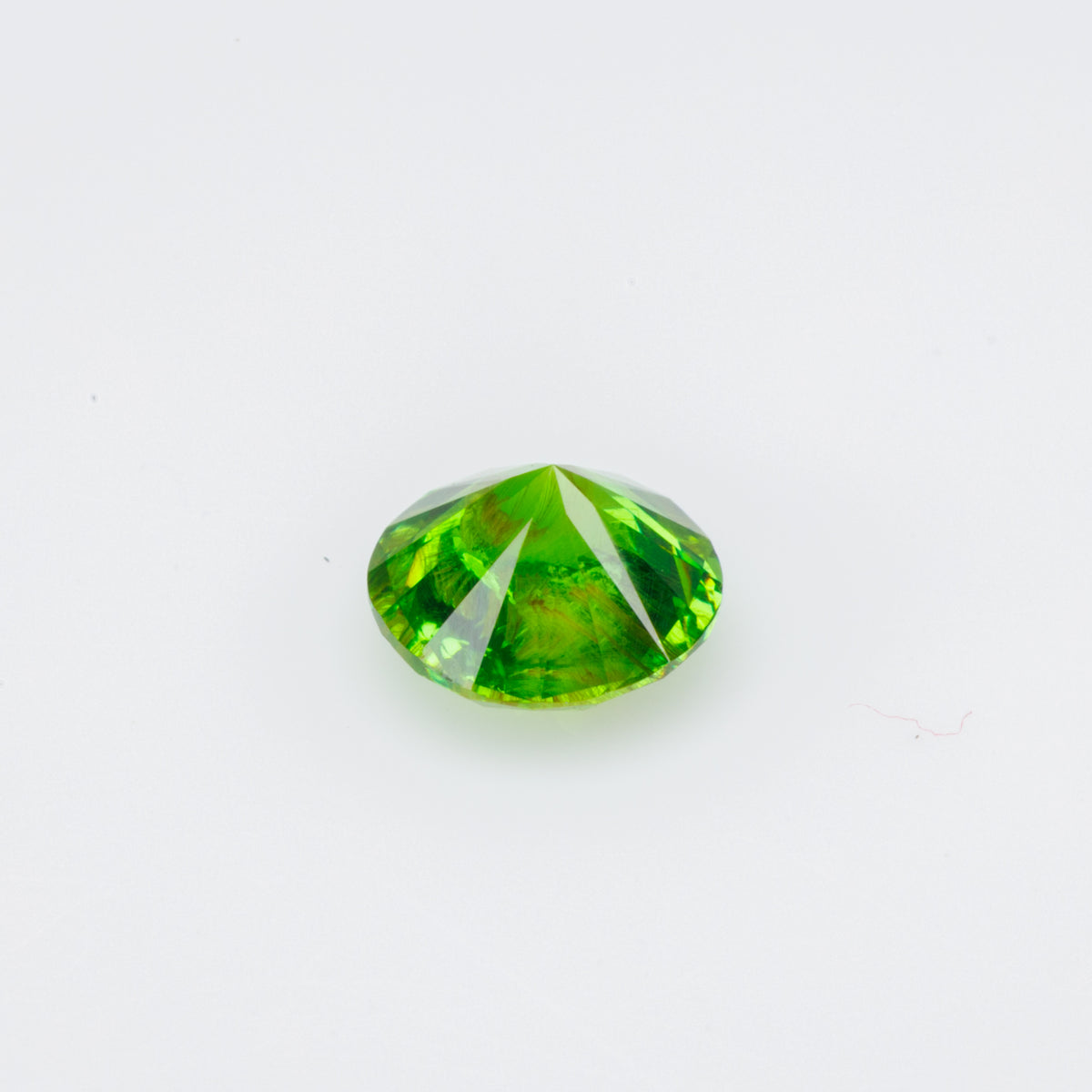 0.47 ct, Faceted Russian demantoid garnet with byssolite inclusion
