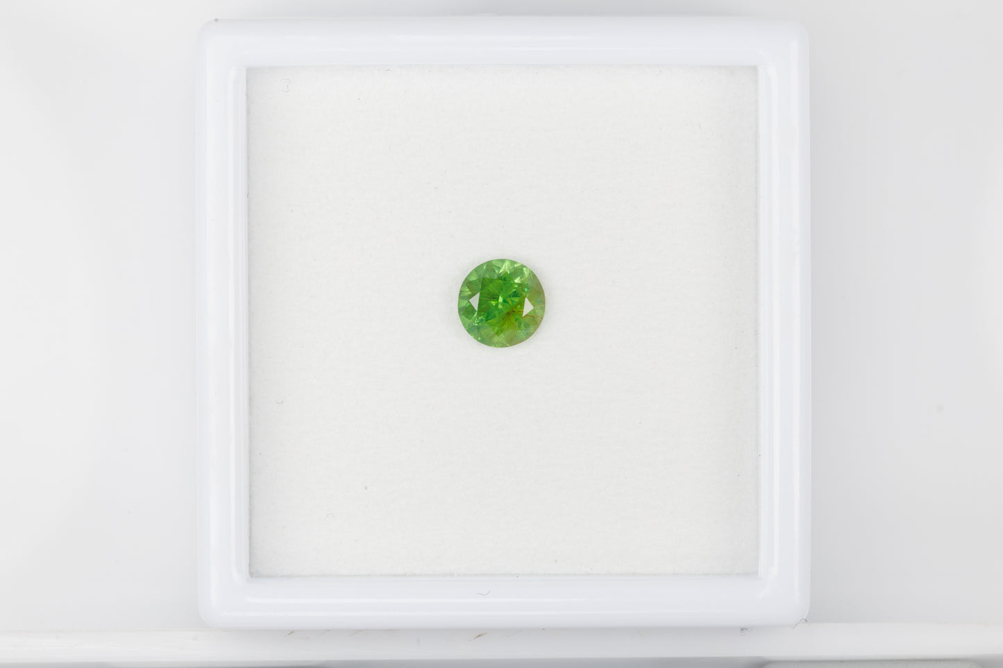 Facted demantoid garnet with obvious horsetail inclusion, 0.7 ct