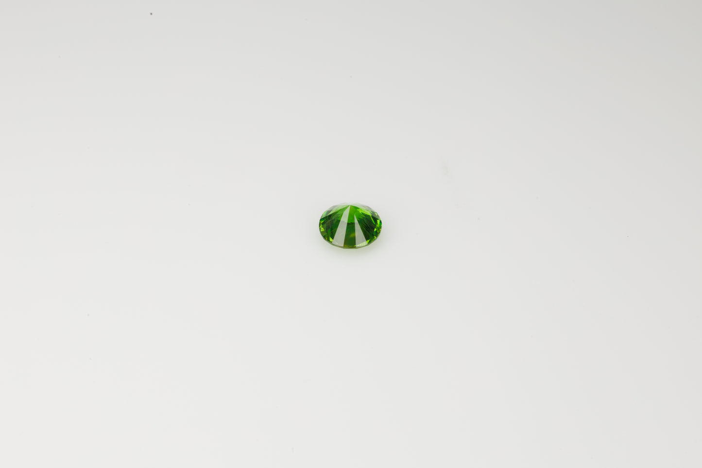 Vivid green faceted Russian demantoid garnet with byssolite inclusions, 0.32 ct