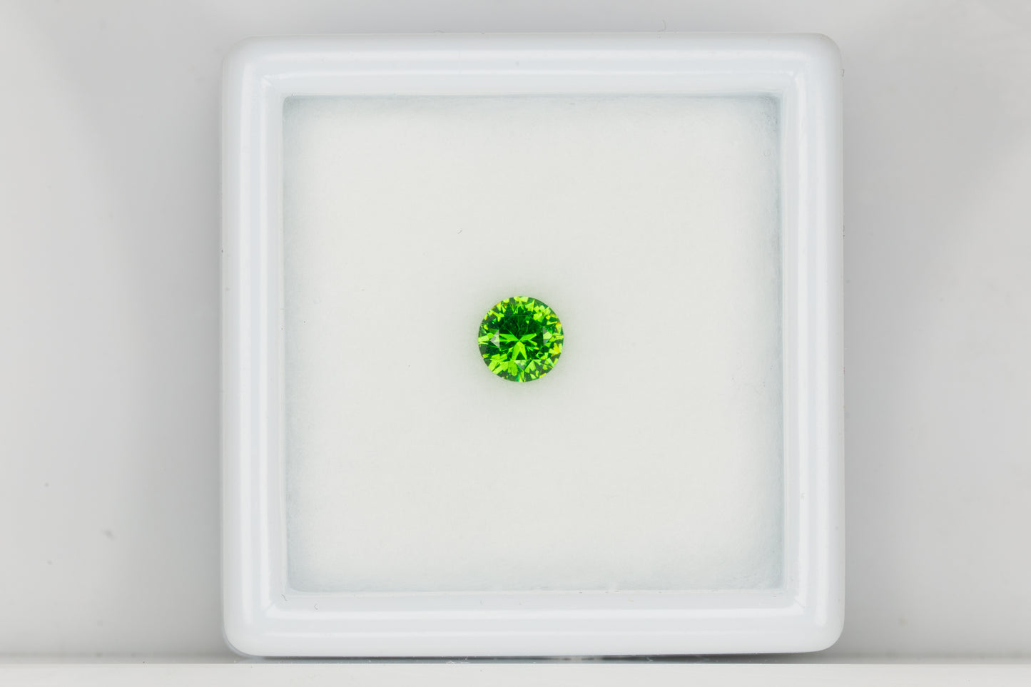 Vivid green faceted Russian demantoid garnet with byssolite inclusions, 0.27 ct