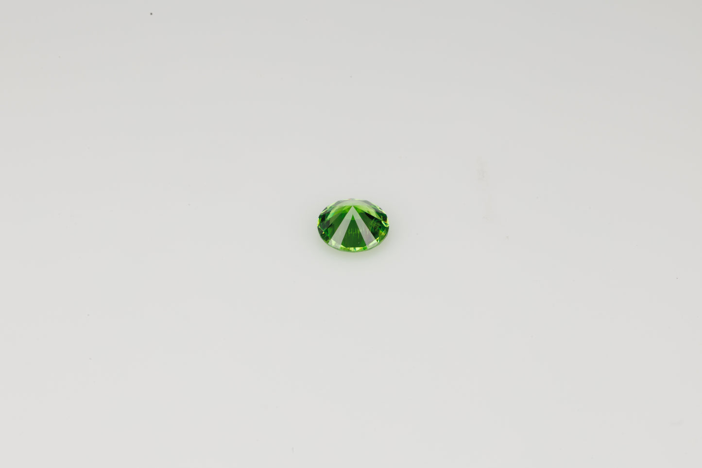Vivid green faceted Russian demantoid garnet with byssolite inclusions, 0.27 ct