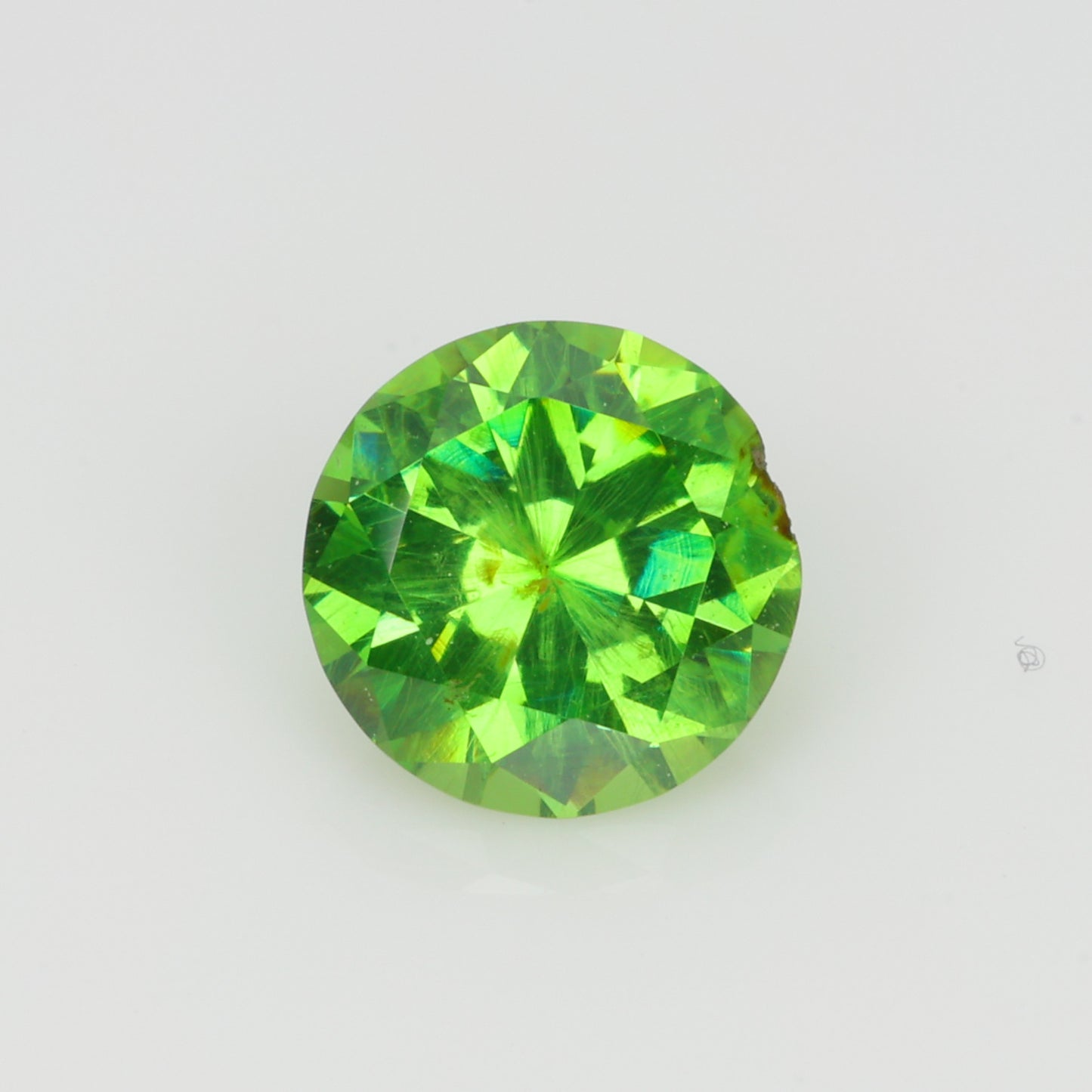 0.52 ct, Faceted Russian demantoid garnet with horsetail byssolite inclusions