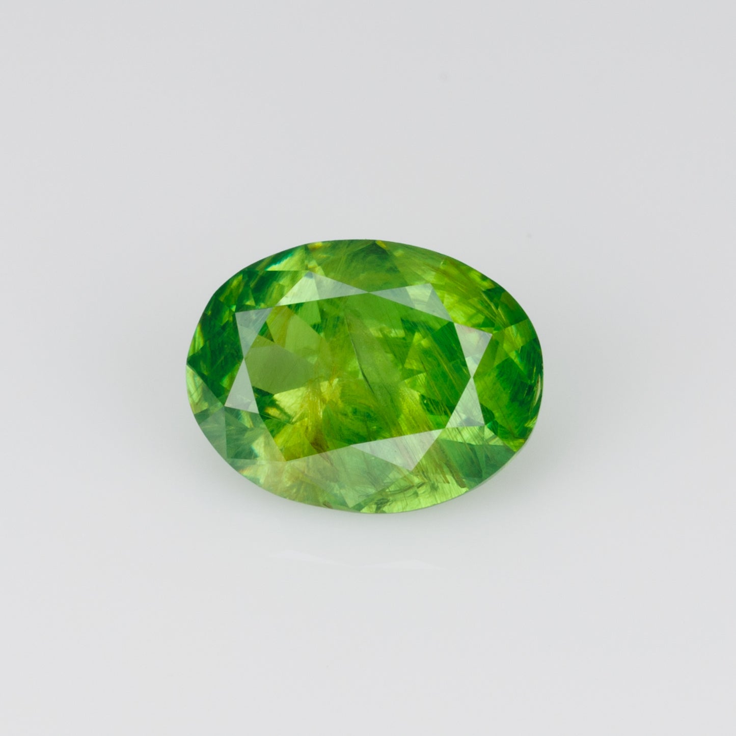 0.98 ct, Certified Russian faceted vivid apple green oval demantoid garnet with byssolite inclusions
