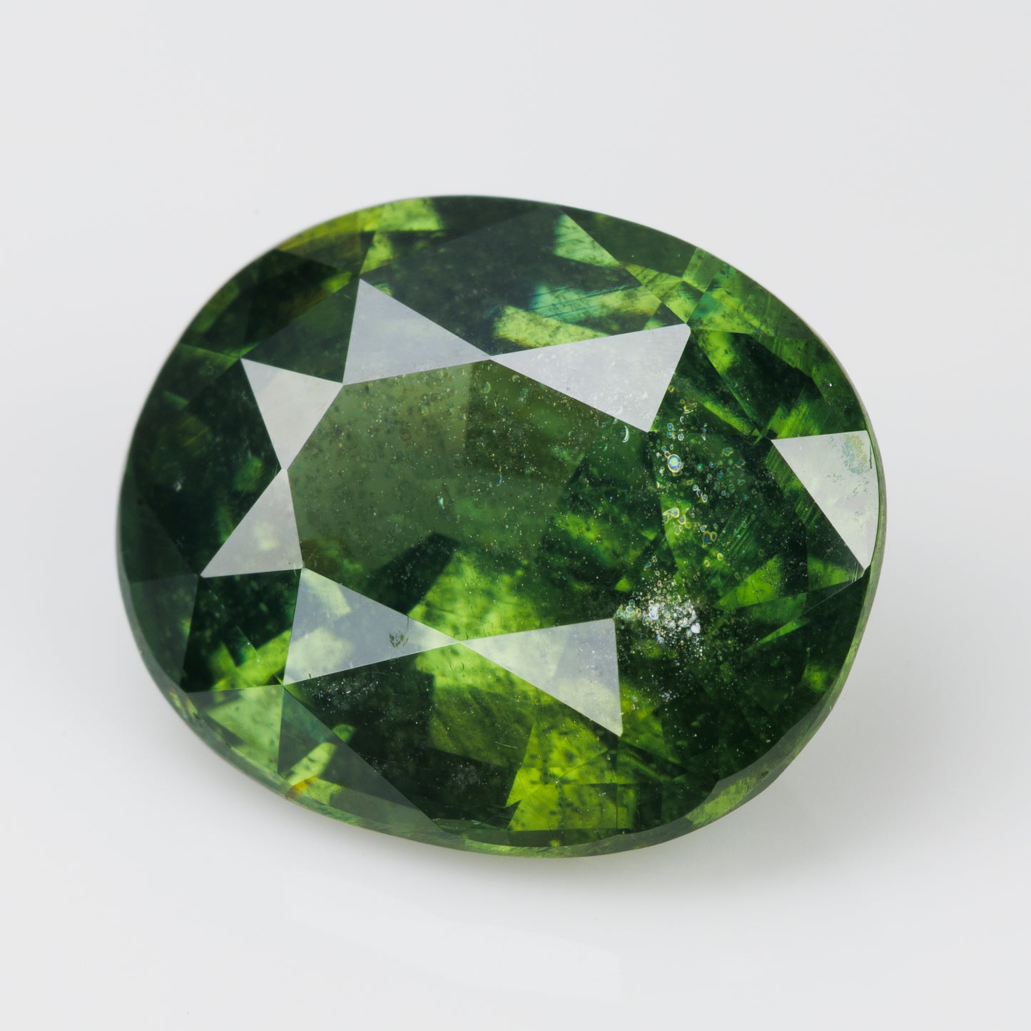 8 cts, Faceted vivid green zircon with amazing glow of the inclusions