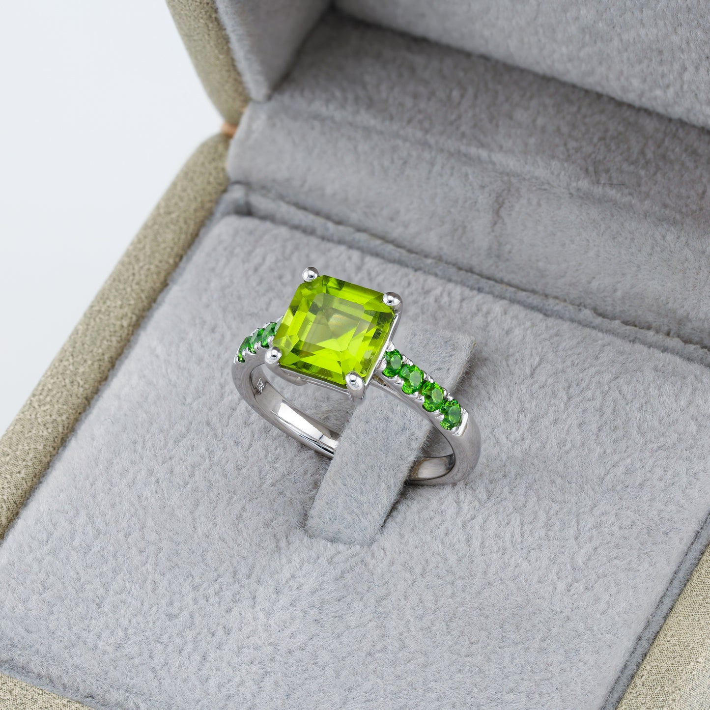 Ring with gold with a yellow-green peridot on a path of Ural demantoids