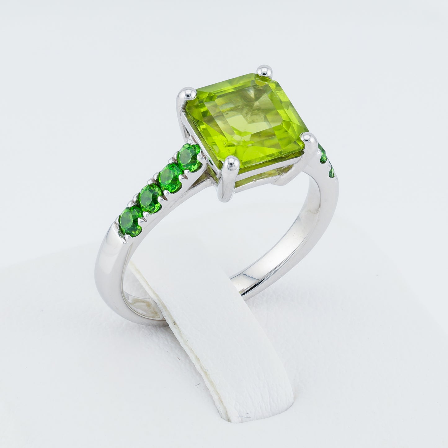 Ring with gold with a yellow-green peridot on a path of Ural demantoids