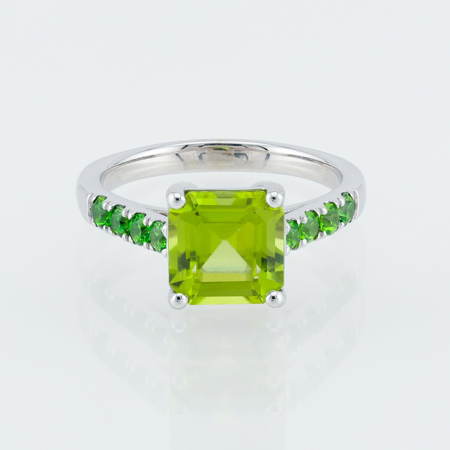 Ring with gold with a yellow-green peridot on a path of Ural demantoids